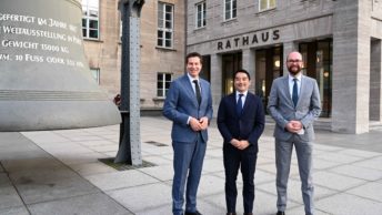 Besuch einer Delegation aus Tsukuba: Thomas Eiskirch (Oberbürgermeister Stadt Bochum), Dr. Tatsuo Igarashi (Oberbürgermeister von Tsukuba), Sebastian Kopietz (Stadtdirektor Stadt Bochum) - zwischen Glocke und neuem Osteingang des Rathauses Bochum