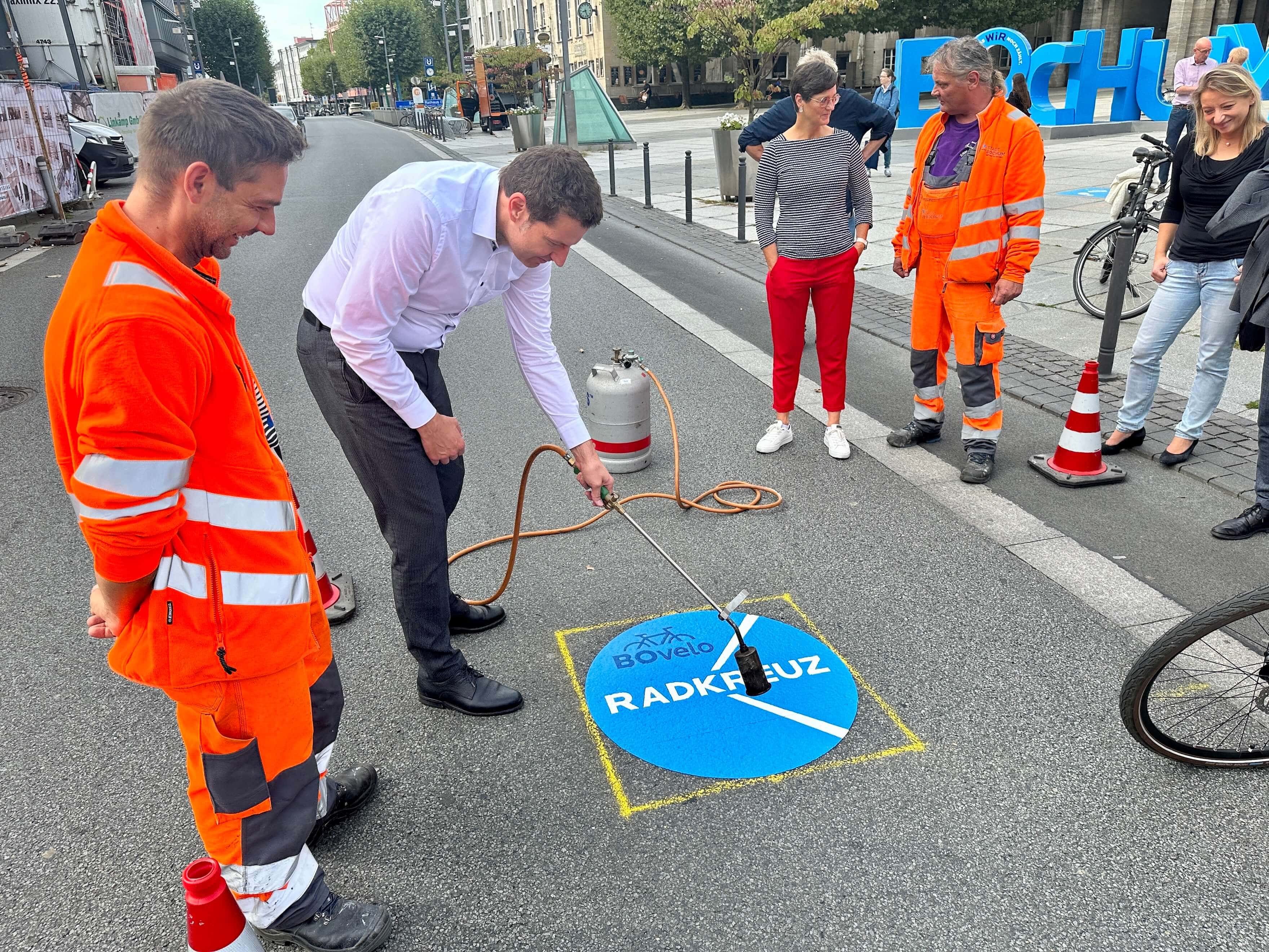 Radkreuz Bochum: Oberbürgermeister Thomas Eiskirch (SPD) bringt das Piktogramm "BOvelo - Radkreuz Bochum" an