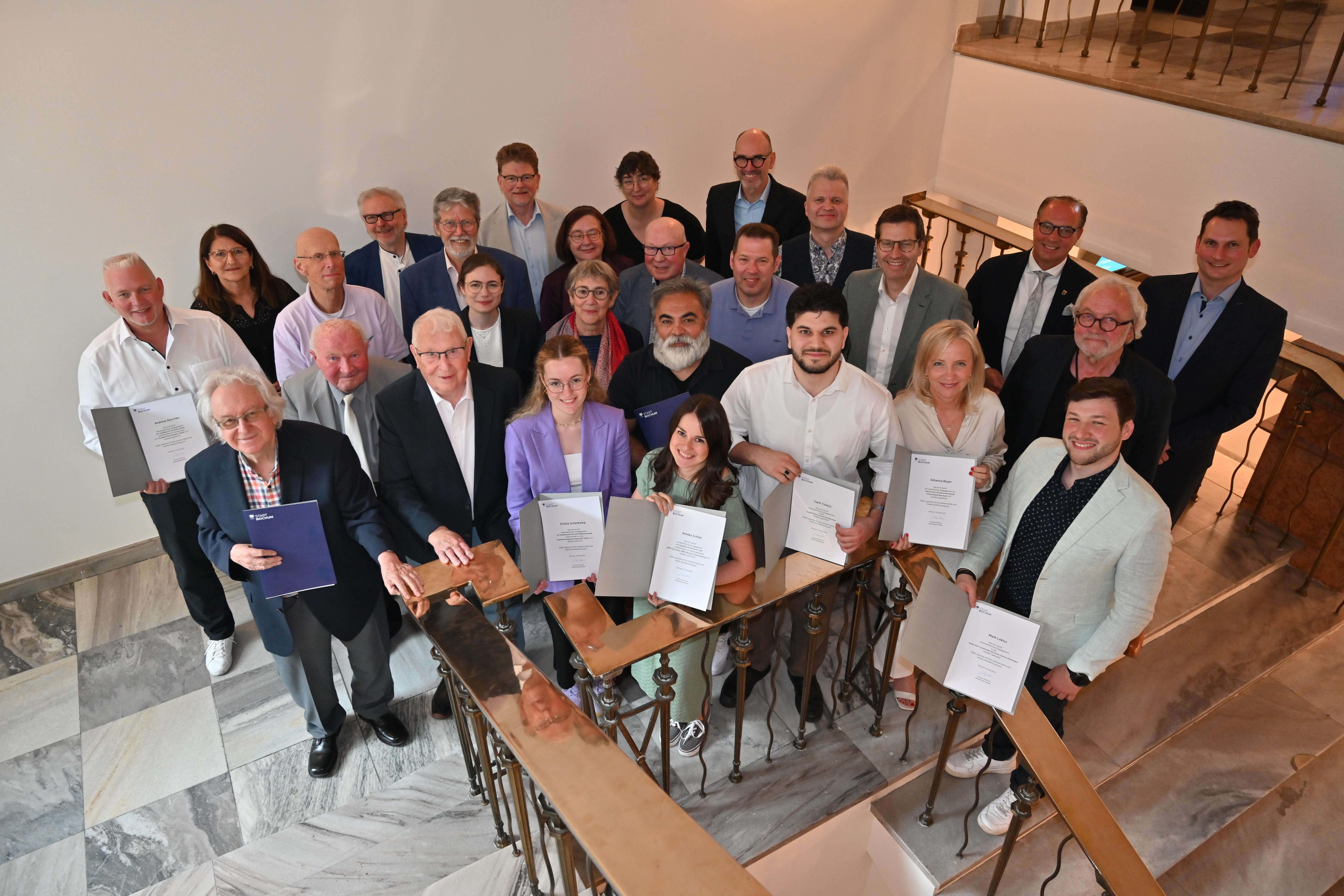 Gruppenbild aller Geehrten mit Urkunden im Rathaus Bochum
