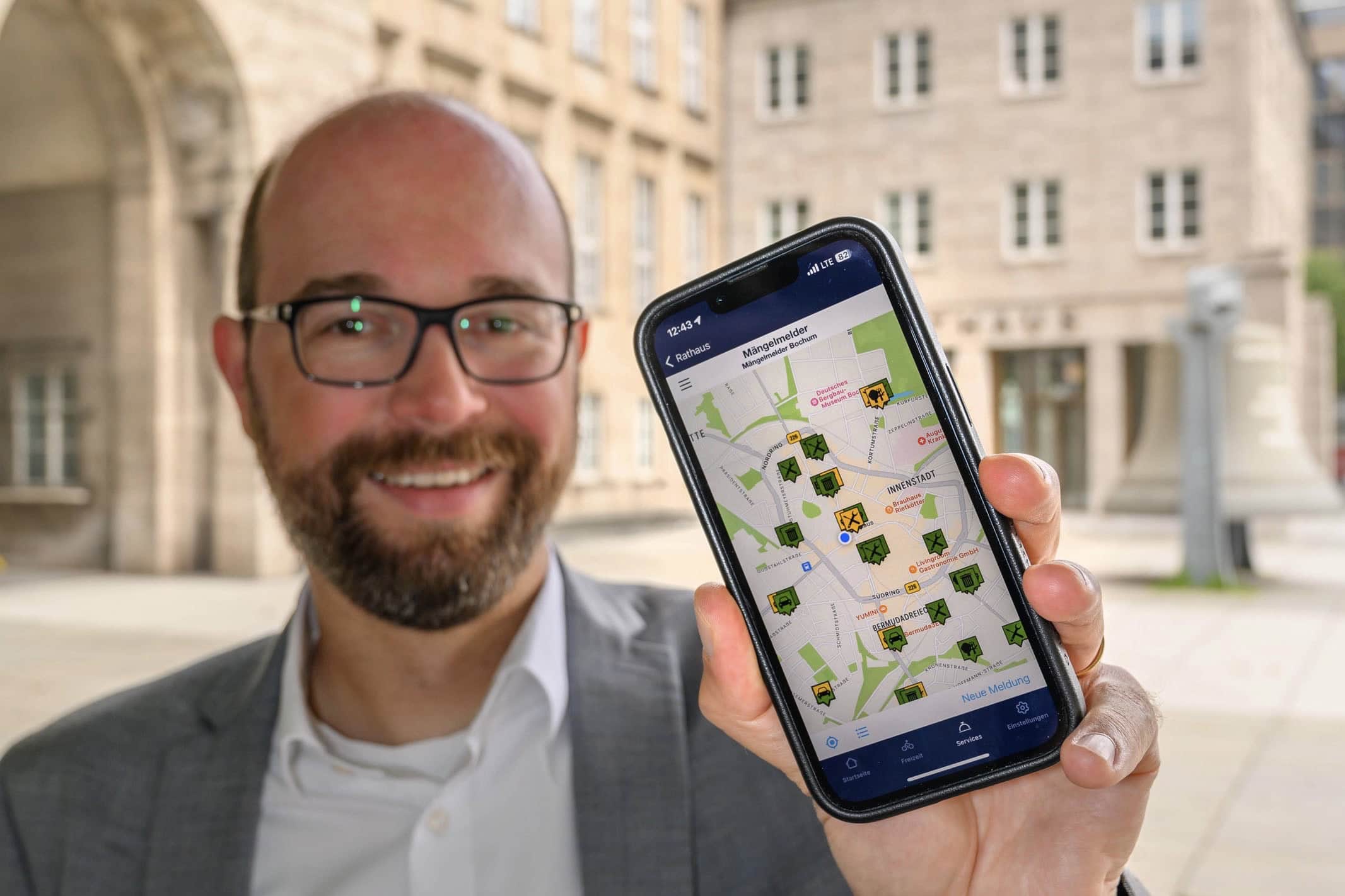 Sebastian Kopietz (mit der neuen M&auml;ngelmelder-App auf einem Handy)